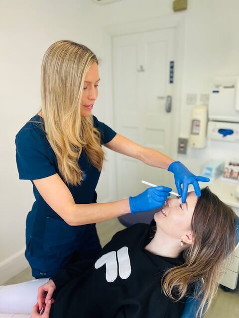 Woman preparing a facial treatment on a patient.